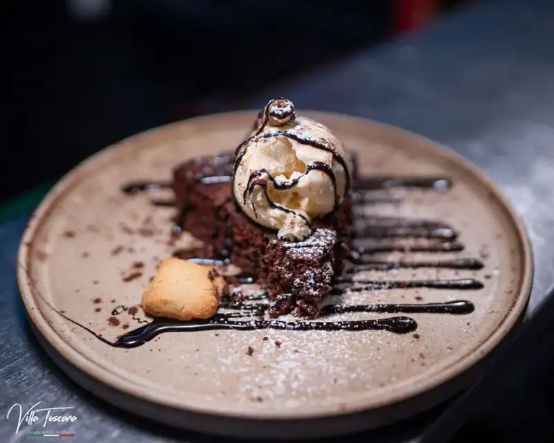Chocolate dessert topped with ice cream and chocolate sauce