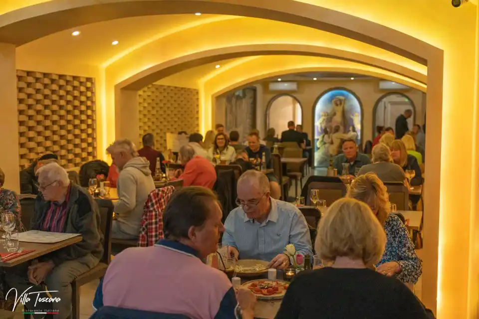 Guests gathered for dinner beneath the warm lights of Villa Toscana