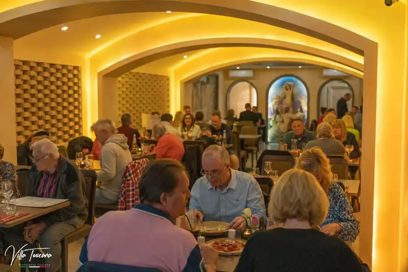 Guests gathered for dinner beneath the warm lights of Villa Toscana